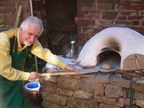 PACT's Peter Dicken using the cob oven at Acorn Bank Apple Day 2011