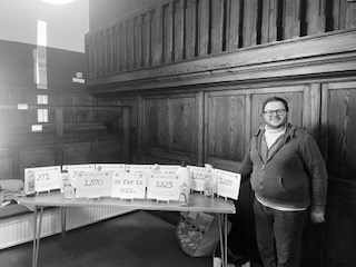 A man stands in front of a display on zero waste shopping.